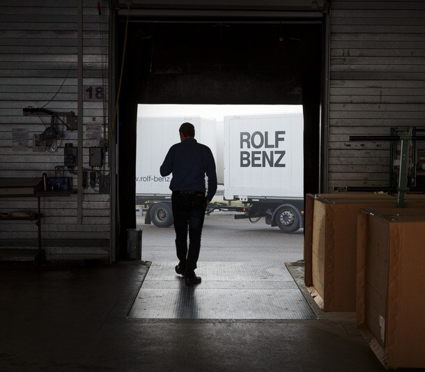 Ein Mann läuft in eine erleuchtete Produktionshalle von Rolf Benz hinein.