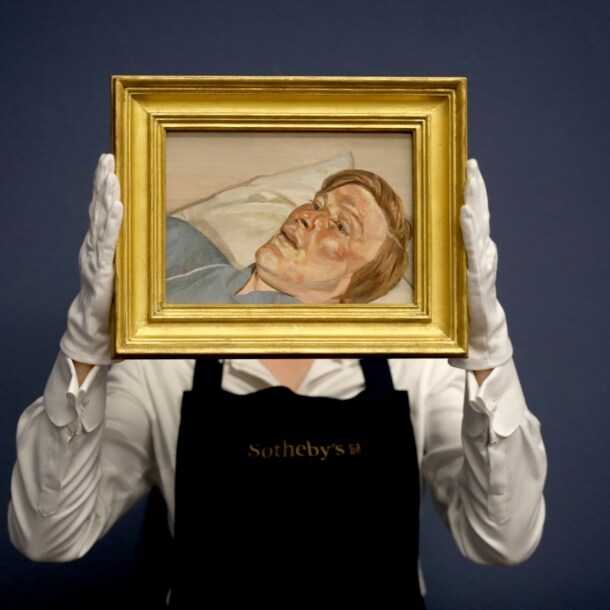 Eine Mitarbeiterin von Sotheby’s hält mit weißen Handschuhen ein kleines Gemälde von Lucian Freud in einem goldenen Rahmen hoch