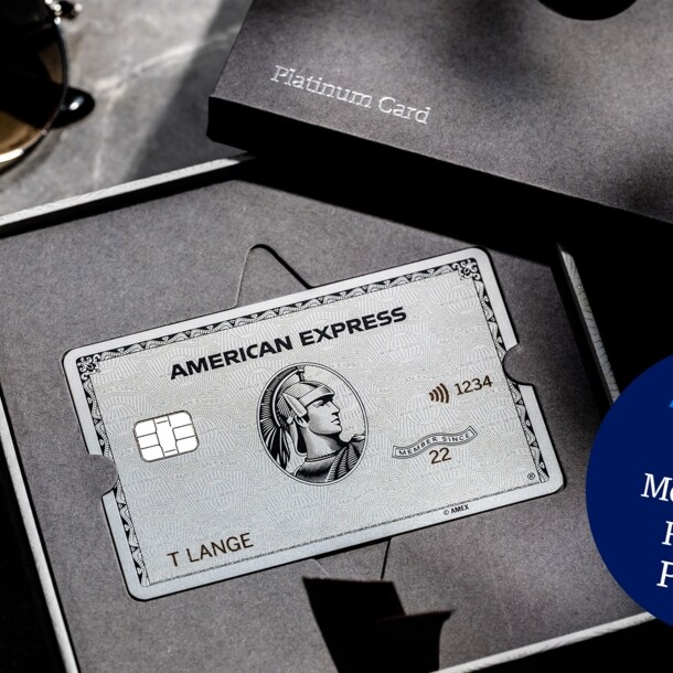 American Express Platinum Card aus Metall in einer geöffneten Präsentationsbox aus grauer Feinkartonage auf einem Marmortisch.