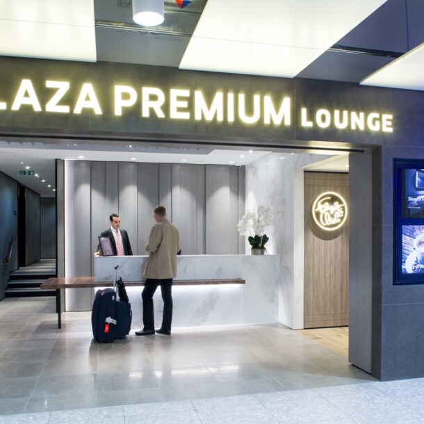 Ein Mann mit Gepäck beim Check-in am Eingang einer Plaza Premium Flughafen-Lounge.