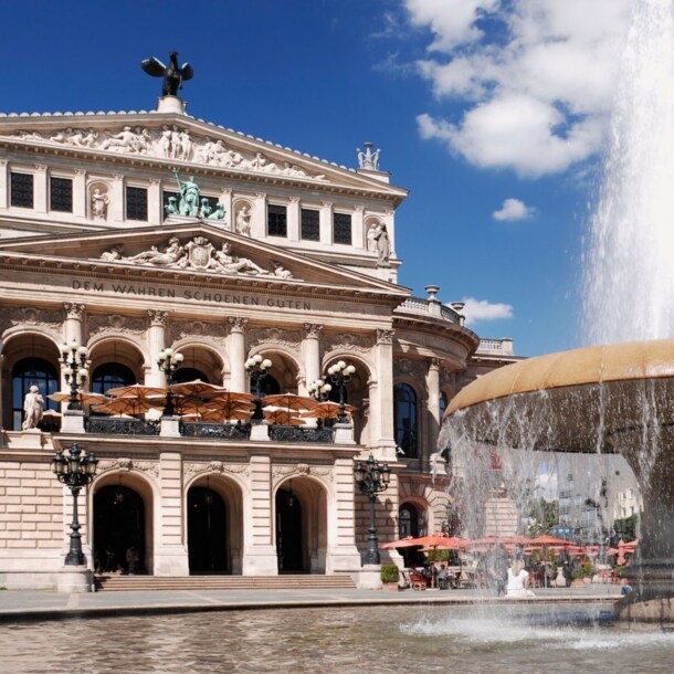 Prachtvolles Operngebäude im Stil der Neorenaissance mit Restaurant, im Vordergrund ein Springbrunnen.