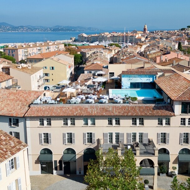 Blick auf das Hôtel de Paris Saint-Tropez mit Dachgarten und Rooftop-Pool, im Hintergrund das Mittelmeer.