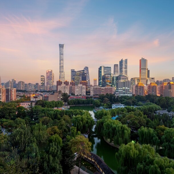 Erleuchtete Skyline von Peking mit Parkanlage in der Dämmerung.