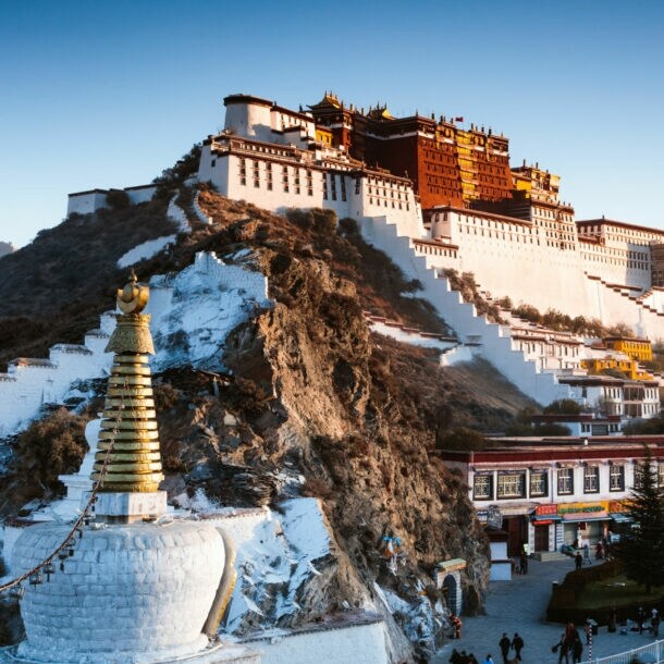 Buddhistische Tempelanlage auf einem Berg vor Gipfelpanorama.