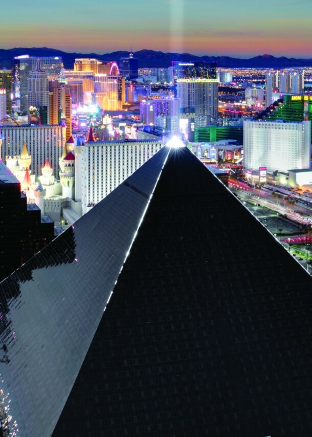 Luftaufnahme von Las Vegas bei Nacht mit einem schwarzen, pyramidenförmigen Gebäude