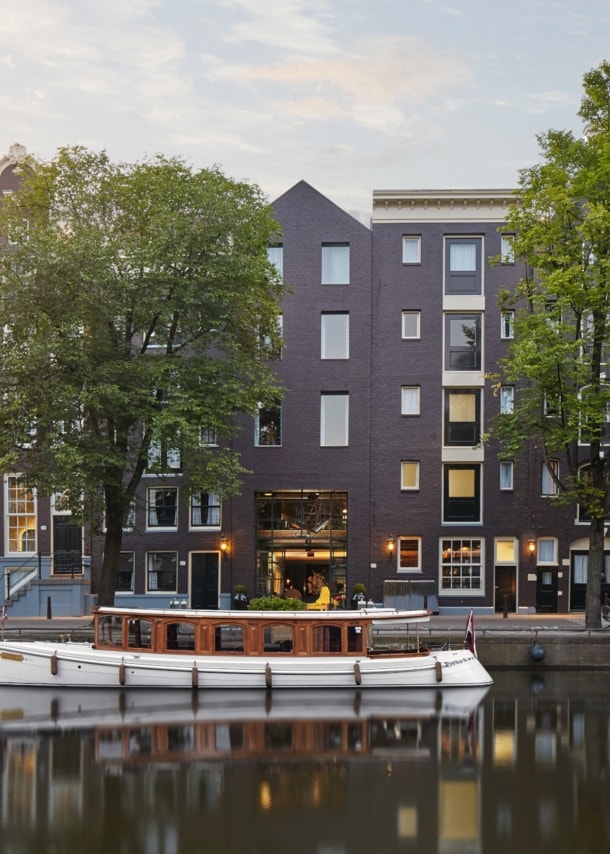 Hotelkomplex aus restaurierten Grachtenhäuser am Kanal mit Boot.