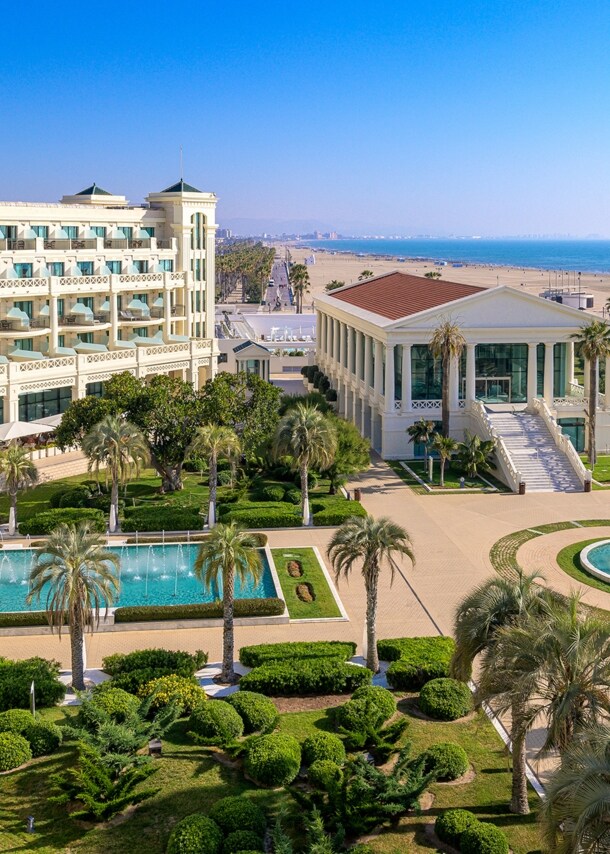 Luxuriöse Hotelanlage mit Pools und Palmengarten an einem breiten Sandstrand.