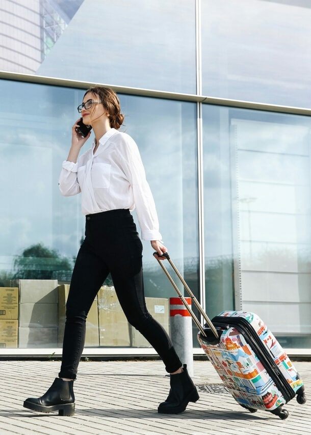 Geschäftsfrau mit Trolli auf dem Weg zum Flughafen