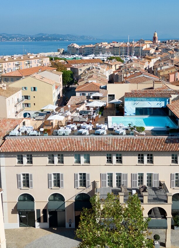 Blick auf das Hôtel de Paris Saint-Tropez mit Dachgarten und Rooftop-Pool, im Hintergrund das Mittelmeer.