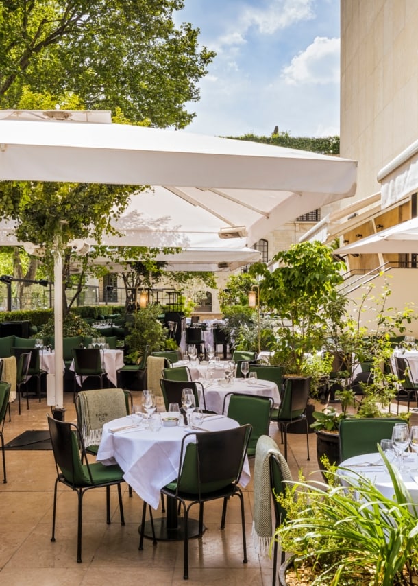 Terrasse eines gehobenen Restaurants mit eingedeckten Tischen.