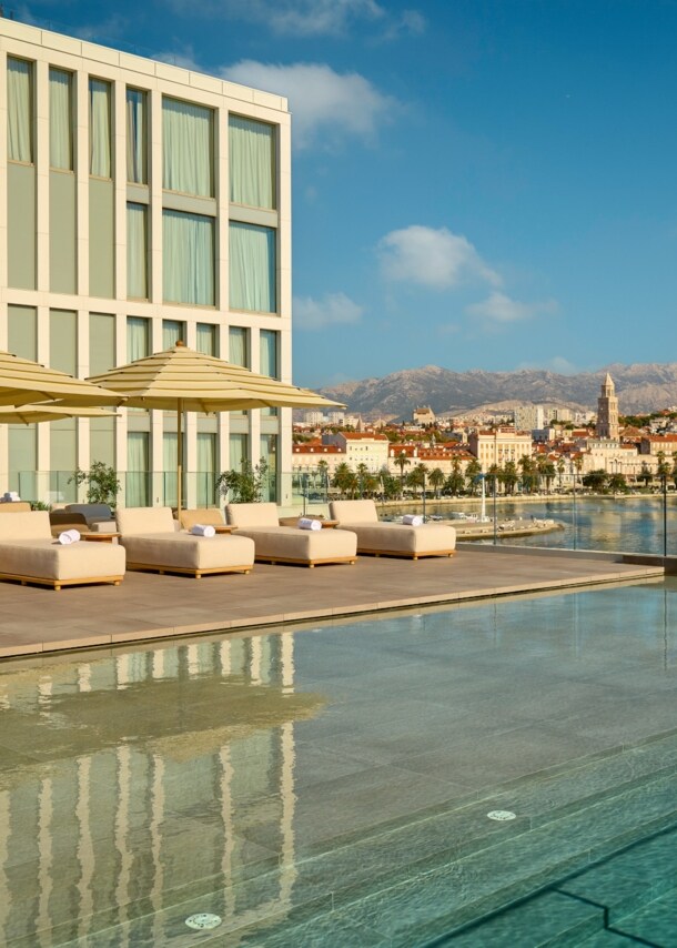 Großer Außenpool mit Liegestühlen auf der Terrasse des Hotel Ambasador in Split.