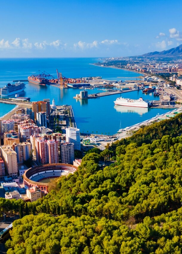 Luftaufnahme von Málaga mit Meer und Bergen im Hintergrund.