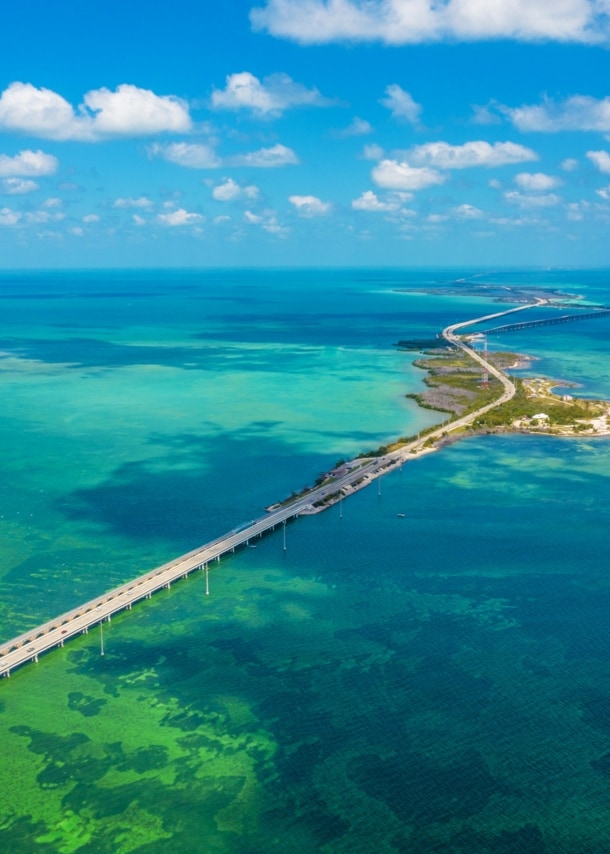 Lange Brücke, die kleine Inseln im türkisblauen Meer miteinander verbindet.