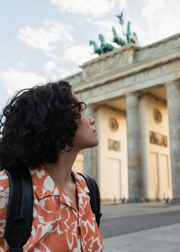 Eine junge Frau schaut auf das Brandenburger Tor