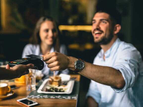 Junges Paar im Restaurant bezahlt mit Kreditkarte