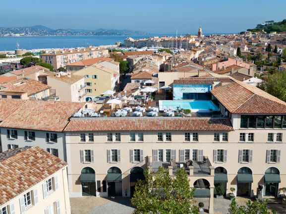 Blick auf das Hôtel de Paris Saint-Tropez mit Dachgarten und Rooftop-Pool, im Hintergrund das Mittelmeer.