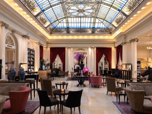 Elegante Hotellobby mit Glasdecke im Jugendstil.