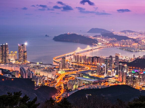 Panorama der hell erleuchteten Stadt Busan in Südkorea bei Nacht.