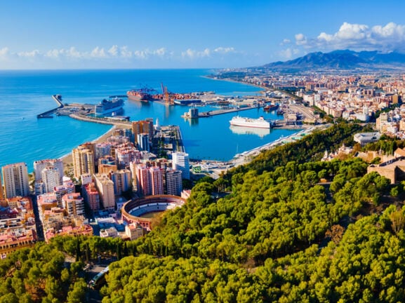 Luftaufnahme von Málaga mit Meer und Bergen im Hintergrund.