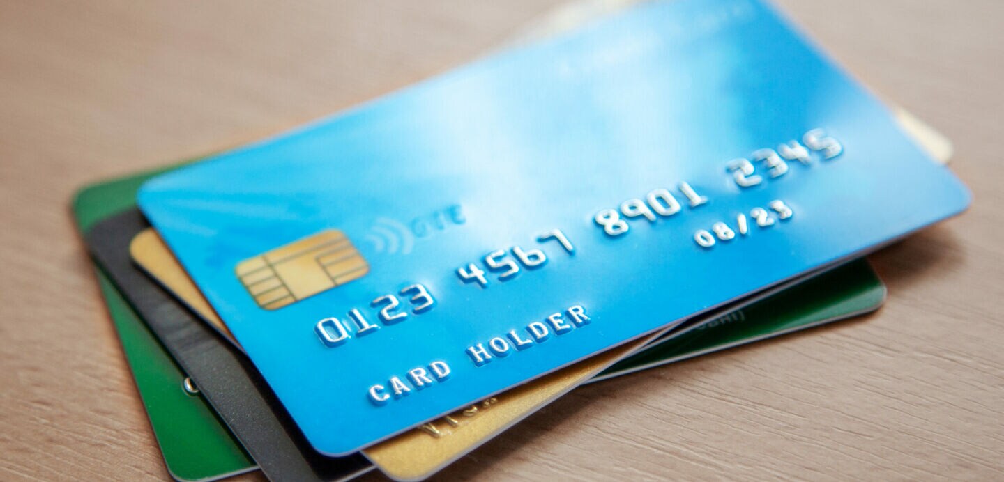 Pile of credit cards on wooden table. Open access for online shopping