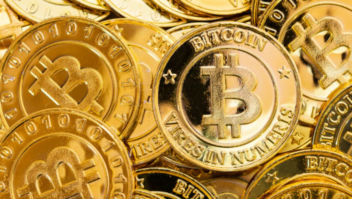 Diverse goldene Münzen, die das international bekannte Symbol für Bitcoin tragen