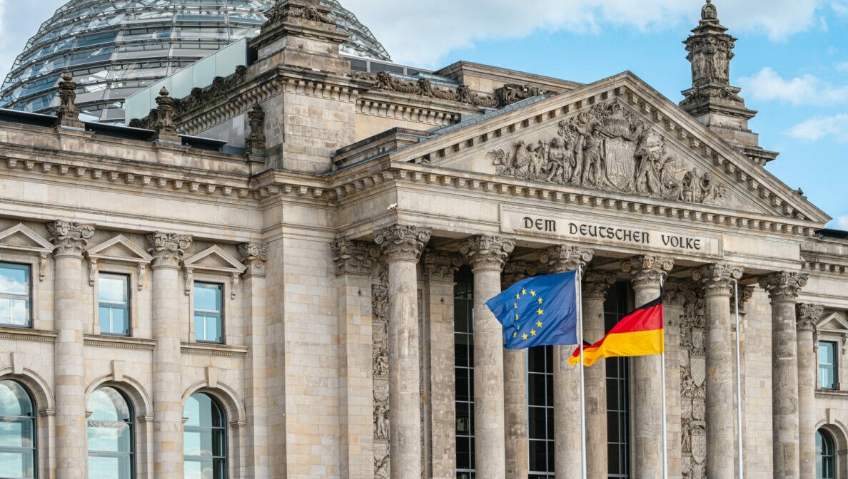 Die Flagge der EU und die deutsche Flagge wehen vor dem Reichstagsgebäude.