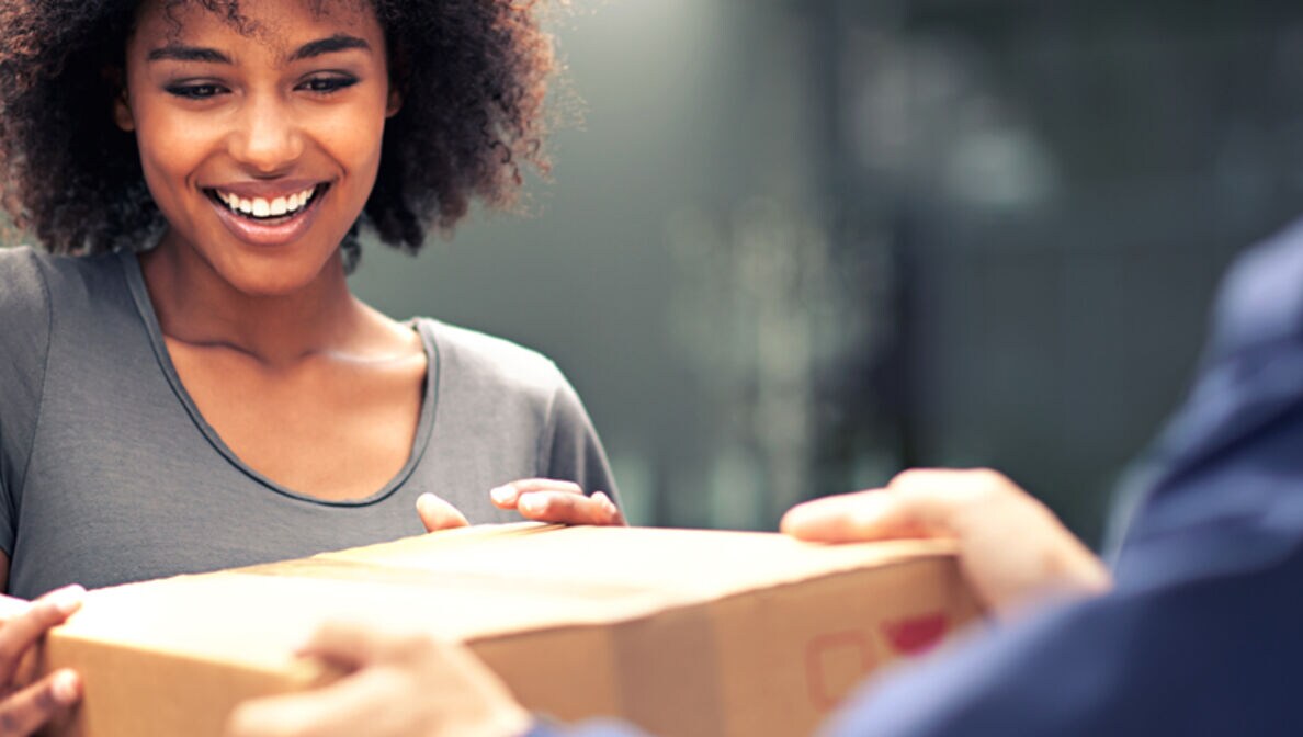 Frau enthält lächelnd ein Paket