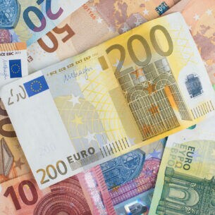 Mehrere Euroscheine liegen verteilt auf einem unbekannten Untergrund