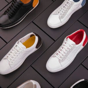 Eine Auswahl von Leder-Sneakern in verschiedenen Farben, die auf schwarzen Schuhkartons platziert sind.