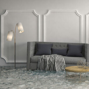 Ein überschwemmtes Wohnzimmer mit Couch, Tisch, Pflanze, Bild und Lampe