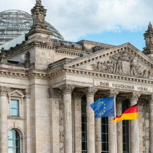 Die Flagge der EU und die deutsche Flagge wehen vor dem Reichstagsgebäude.