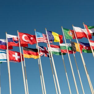 Zahlreiche Fahnenstangen, an denen die Flaggen verschiedener Nationen wehen.