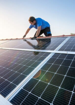 Handwerker installiert Solarmodule auf einem Hausdach