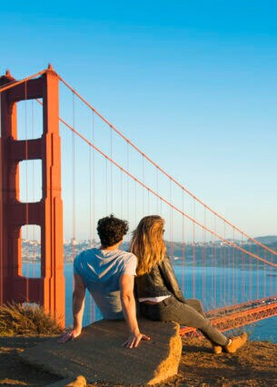 Eine Frau und ein Mann schauen gemeinsam auf die Golden Gate Bridge in San Francisco, USA.
