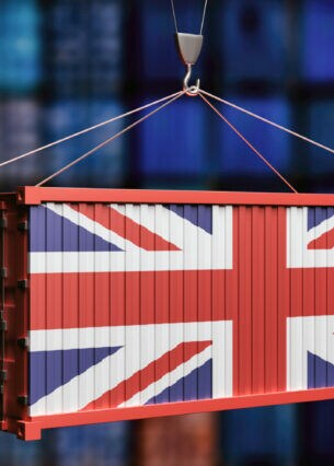 Ein von einem Kran getragener Container, dessen eine Seite die Flagge Großbritanniens darstellt.