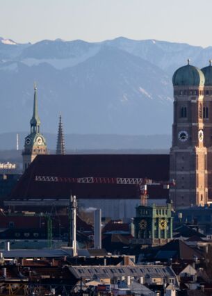 Die Türme des Rathauses (l-r), der Kirche „Alter Peter“ und der Frauenkirche zeichnen sich vor den Alpen ab. (zu dpa: «Start-ups bekommen mehr Geld - Bayern überholt Berlin»)